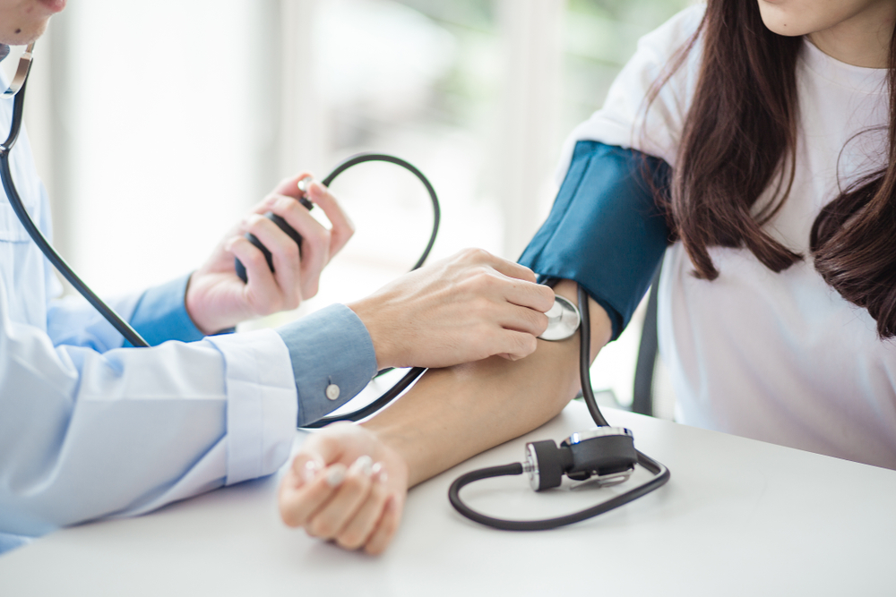 Doctor taking patient’s blood pressure